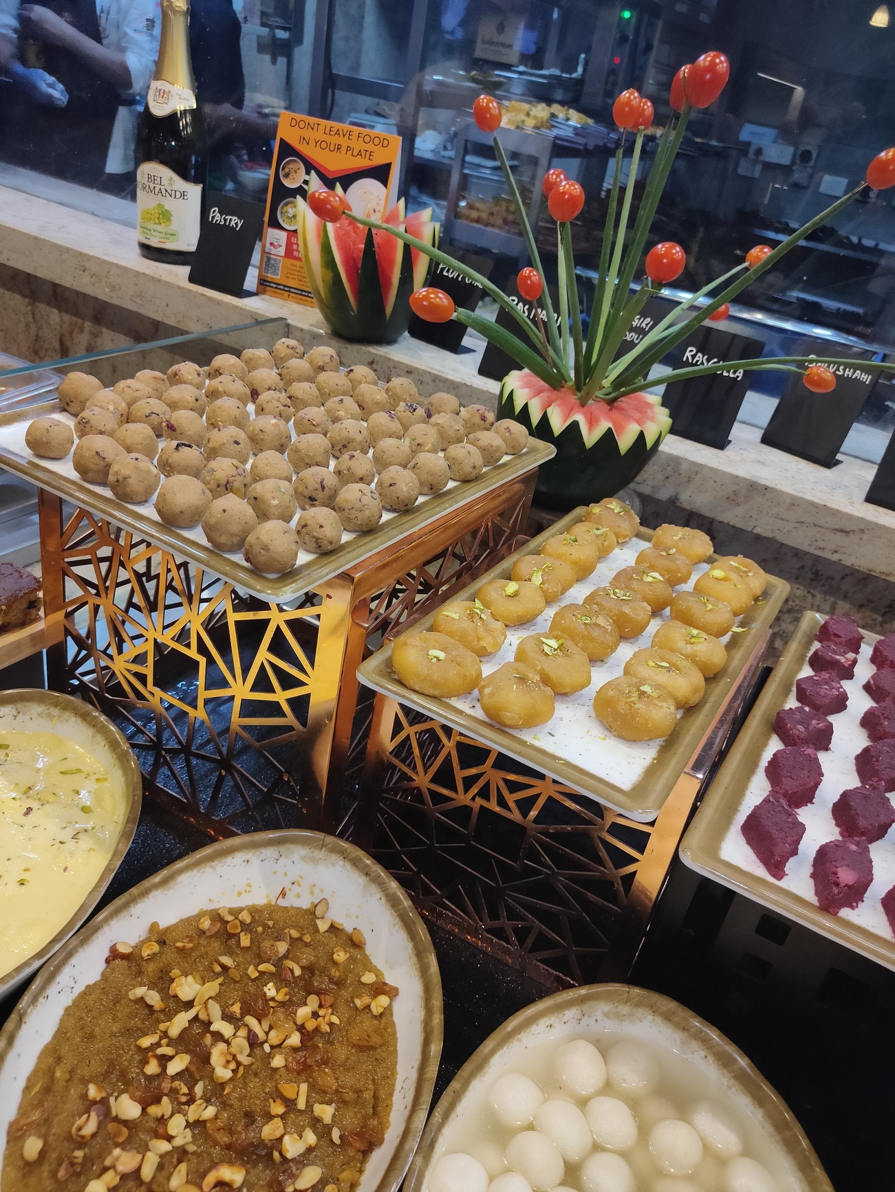Exquisite dessert display with traditional Indian sweets and artistic presentations